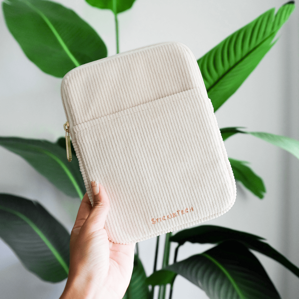 Flat lay of oat corduroy Kindle sleeve with Kindle showing compatibility