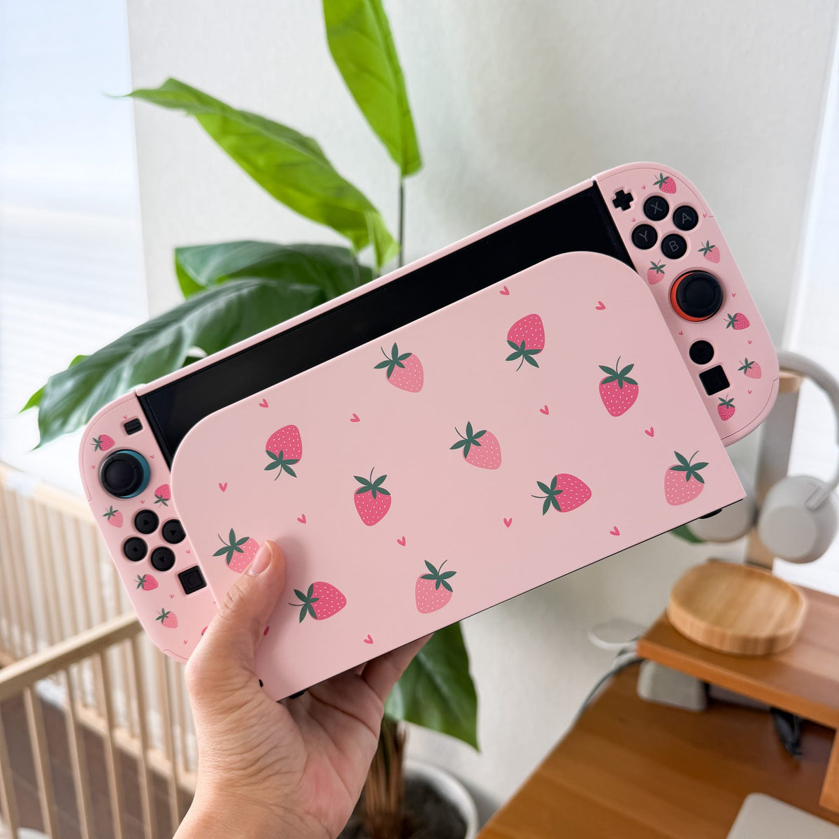 Strawberry Fields Switch 2 protective case, back view in hand